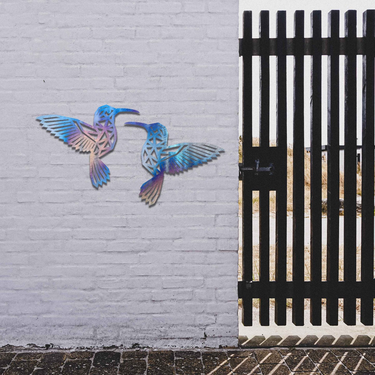 Metal garden decoration featuring two hummingbirds with geometric patterns in a dynamic pose, intricately designed to add elegance and a nature-inspired artistic touch to outdoor walls, fences, or garden sheds
