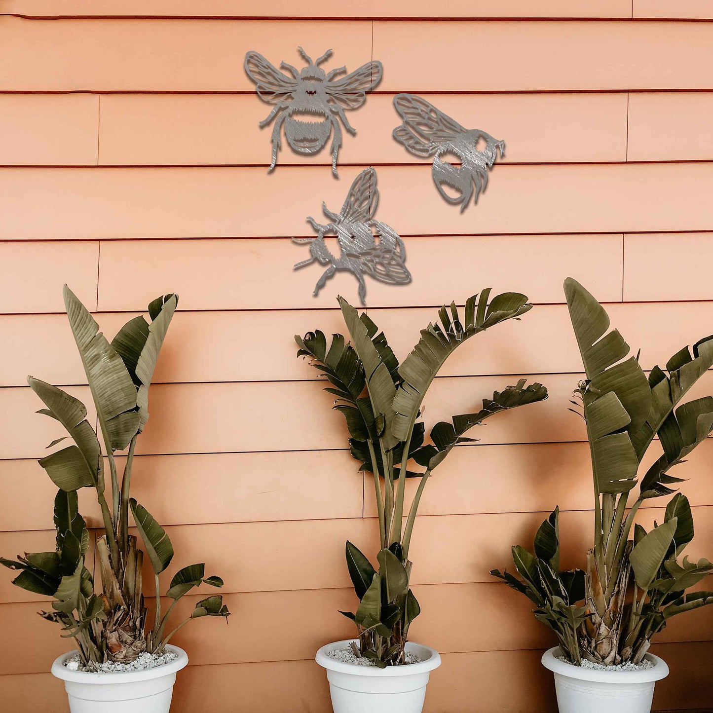 Set of metal garden decorations featuring three detailed bee designs, each showcasing intricate wing and body patterns, perfect for adding a playful and nature-inspired touch to outdoor spaces or fences.
