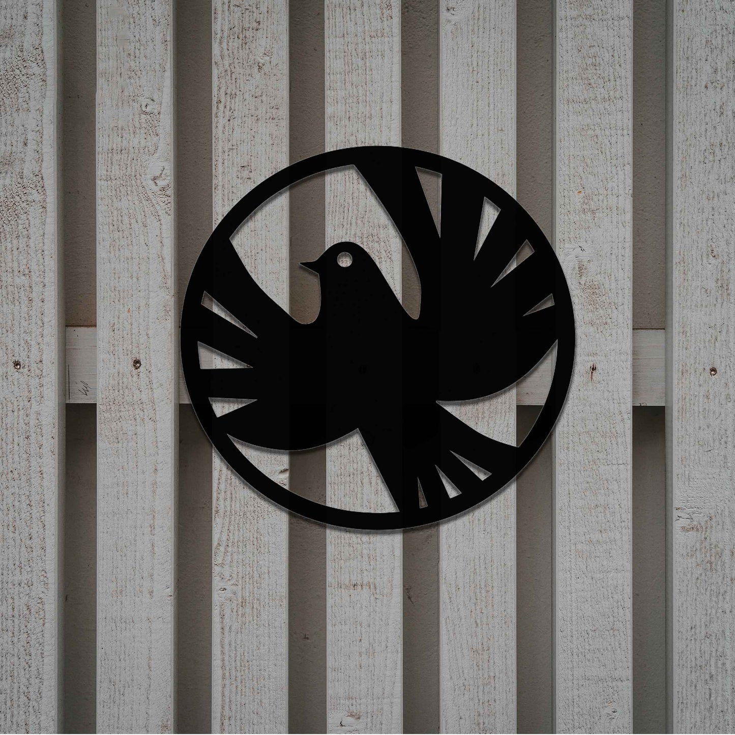 Metal garden decoration featuring a dove silhouette within a circular frame, crafted with minimalist yet elegant detailing, symbolising peace and adding a refined artistic touch to outdoor walls or fences.