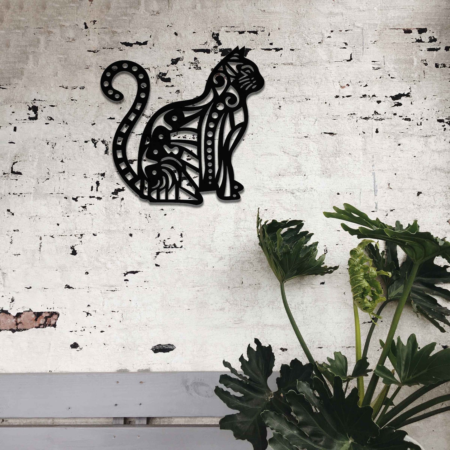 Metal garden decoration featuring a sitting cat with an intricate geometric and swirl pattern, adding a playful and artistic touch to outdoor walls or garden settings.