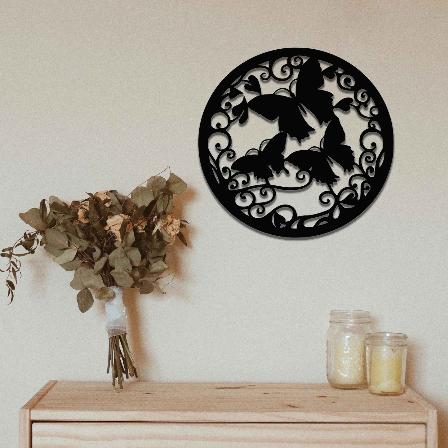 Metal garden decoration featuring a circular design with intricate butterflies and swirling vine patterns, adding a touch of elegance and nature-inspired artistry to outdoor or indoor spaces.
