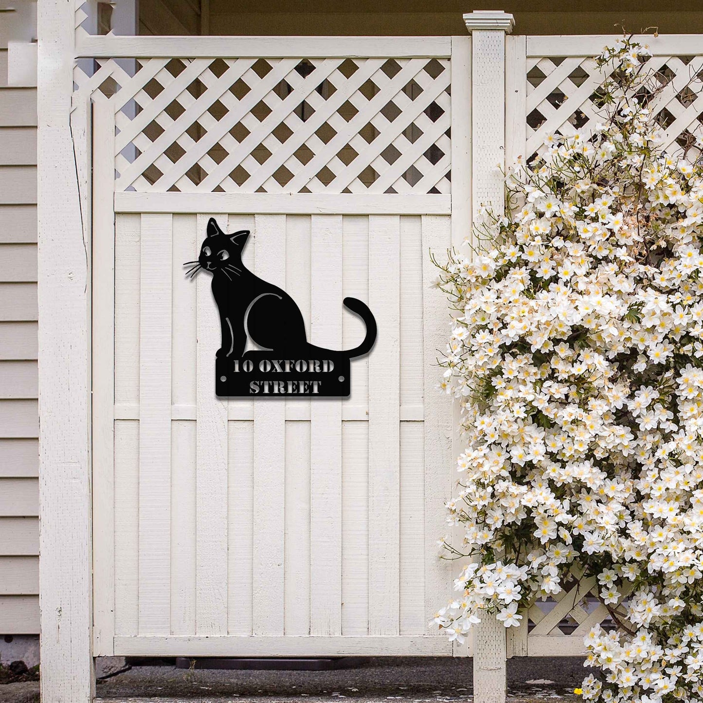 Metal garden decoration featuring a sleek sitting cat silhouette with a personalised address plaque, combining practicality with artistic charm for outdoor walls, fences, or gates.