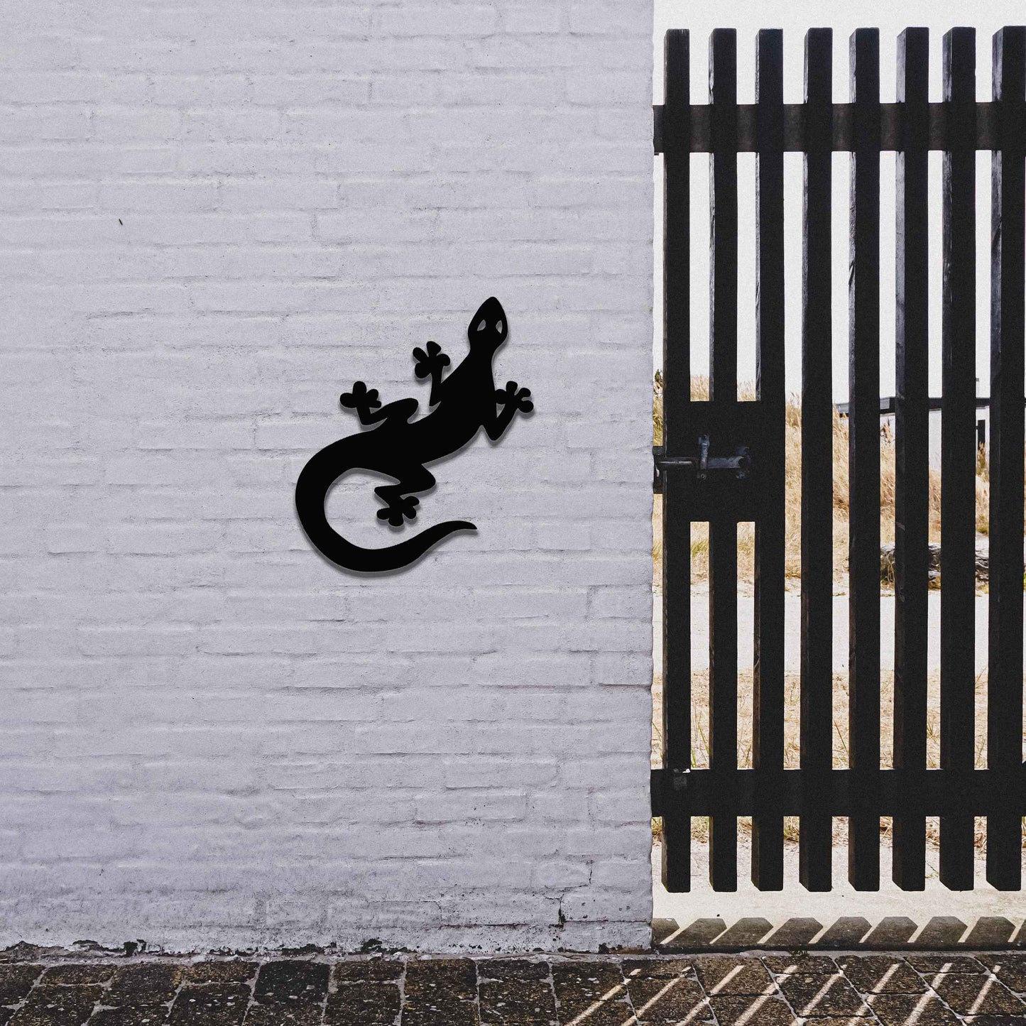 Metal garden decoration featuring a playful gecko silhouette with distinct rounded feet and curved tail, adding a modern and lively touch to outdoor walls, perfectly suited for rustic and contemporary garden settings.