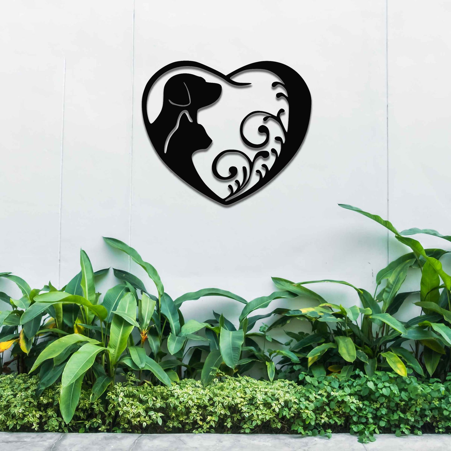 Metal garden decoration featuring a heart-shaped design with silhouettes of a dog and cat intertwined with elegant scrollwork, symbolising love for pets and adding a decorative charm to outdoor walls or garden spaces.