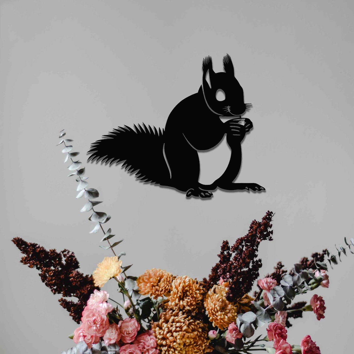 Metal wall decoration featuring a squirrel design with intricate details, adding a playful and artistic touch to indoor spaces, displayed on a neutral wall to highlight its elegant craftsmanship.