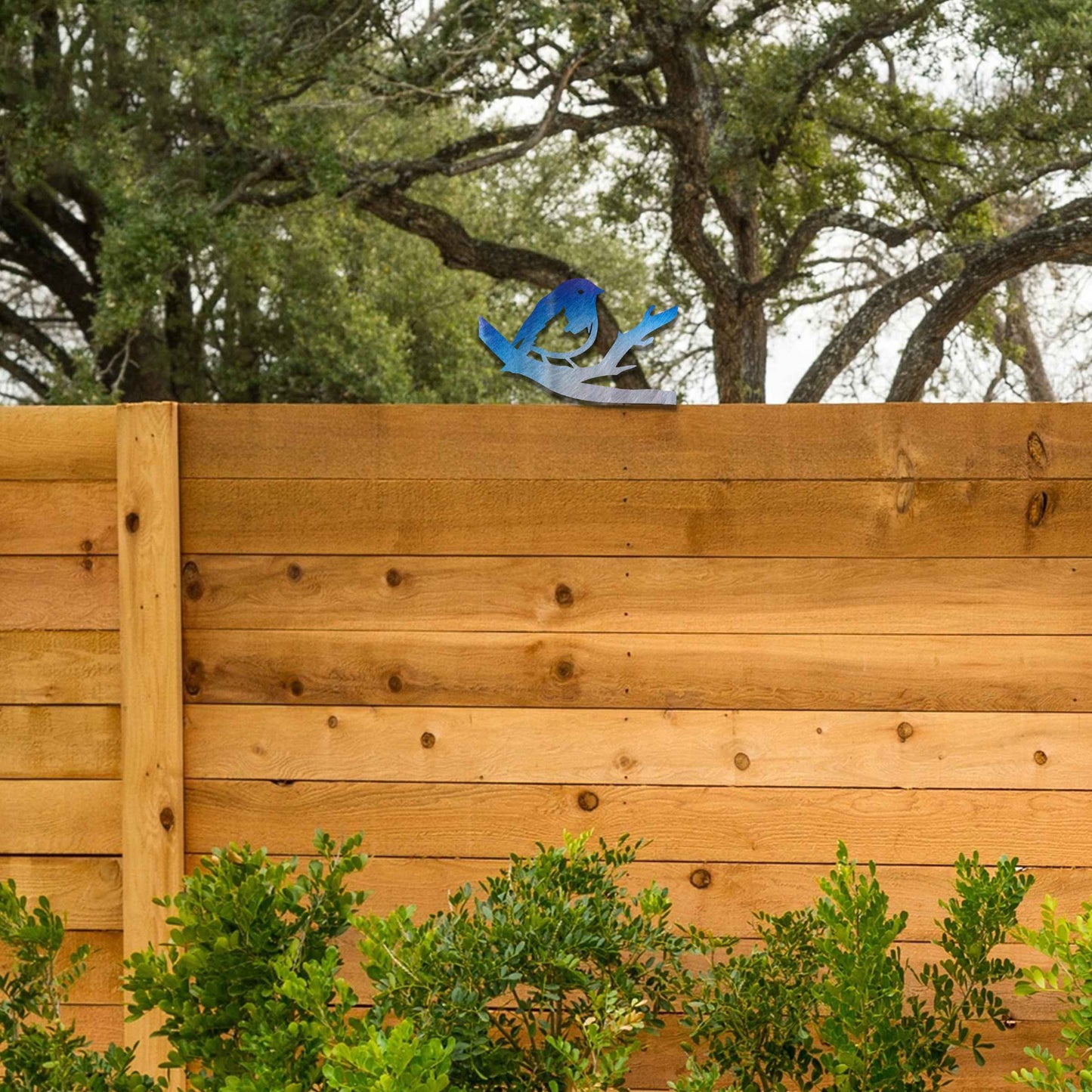 Metal garden decoration featuring a bird perched on a branch with intricate cutout details and a rustic finish, designed to adorn wooden posts or beams, adding a charming and natural accent to outdoor spaces.