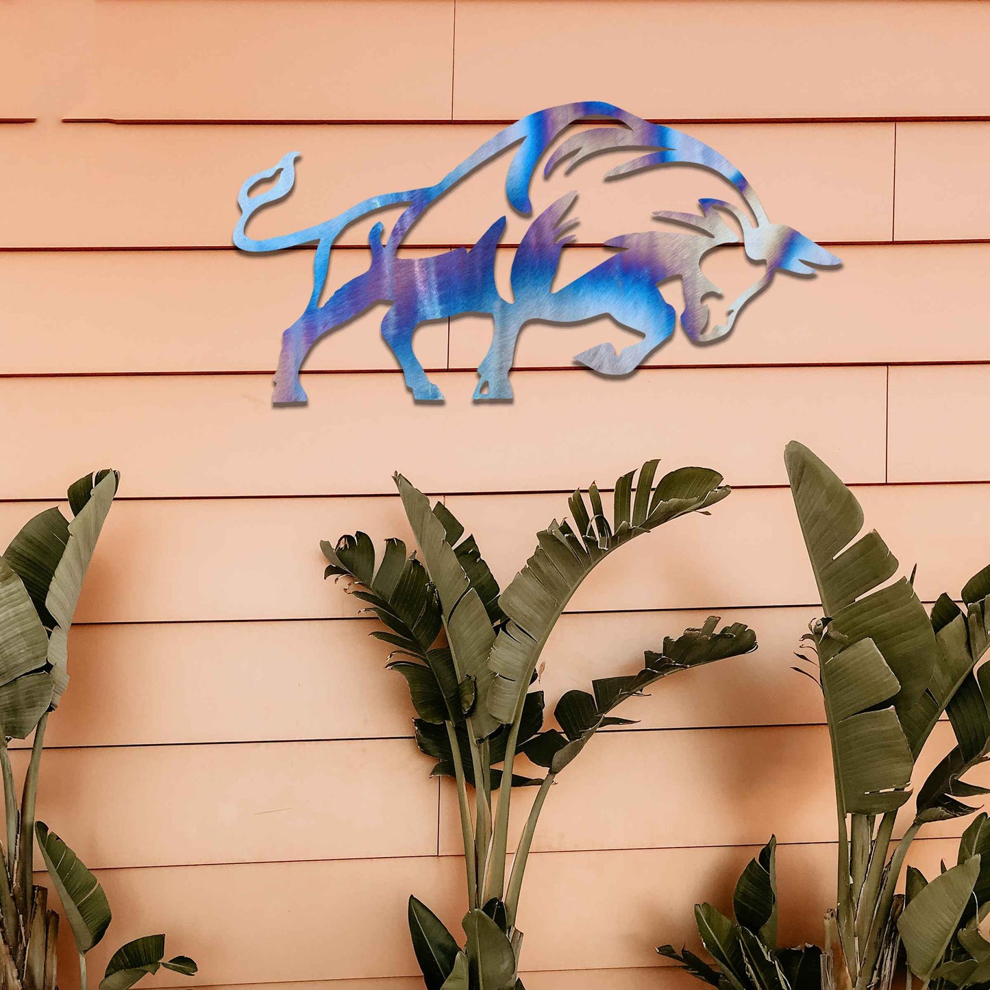 The design presents a powerful bull in motion, with strong, clean lines and a dynamic posture. The bull’s form is bold, enhanced with stylized elements that emphasize its strength. The natural rust finish adds a rugged and textured quality to the piece, accentuating its raw energy.