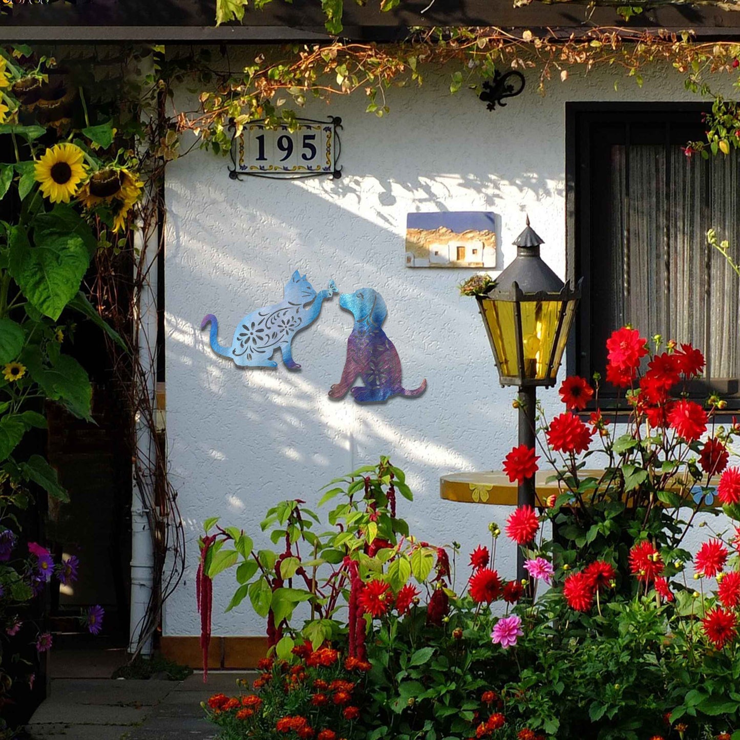 Metal garden decoration set featuring a playful cat reaching for a butterfly and a sitting dog, both adorned with intricate floral patterns, adding a whimsical and charming touch to outdoor walls or fences.