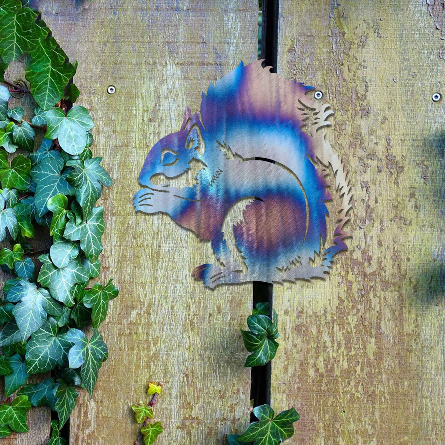 Metal garden decoration featuring a squirrel design with intricate cutout details, adding a whimsical and rustic charm to outdoor walls, blending seamlessly with natural garden surroundings.
