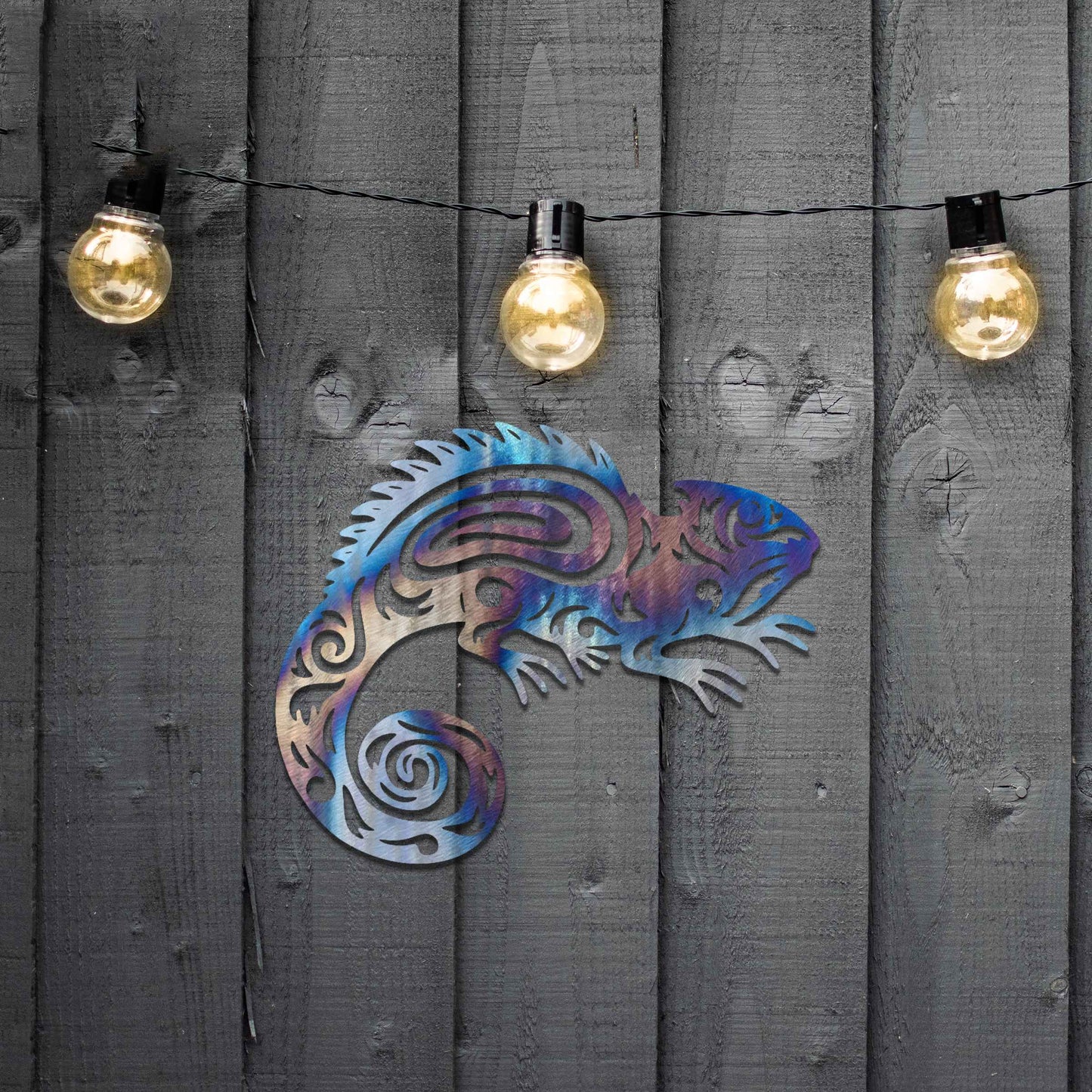 Metal wall decoration featuring a chameleon design with intricate tribal-inspired cutouts, adding an exotic and artistic touch to indoor spaces, displayed on a neutral wall in modern decor.