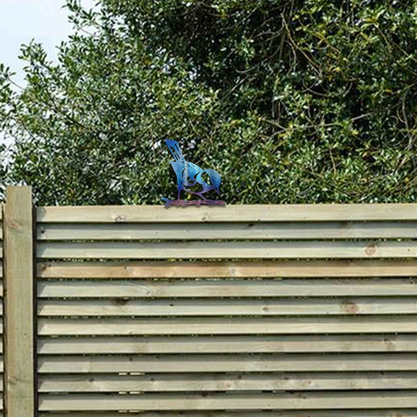 Metal garden decoration featuring a bird silhouette with a rustic finish, perched on a branch, designed to enhance fence tops or wooden posts, adding a natural and charming touch to outdoor spaces.