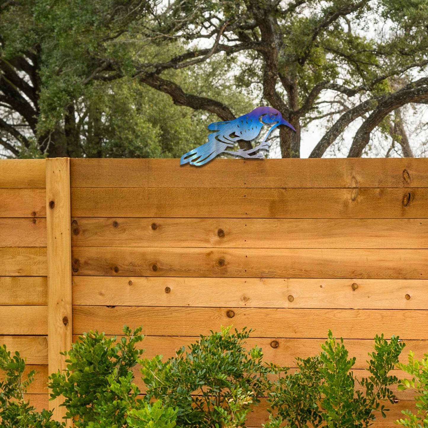 Metal garden decoration featuring a bird silhouette with intricate cutout details, adding a sleek and modern touch to outdoor spaces, designed to sit gracefully on fence posts or wooden beams.