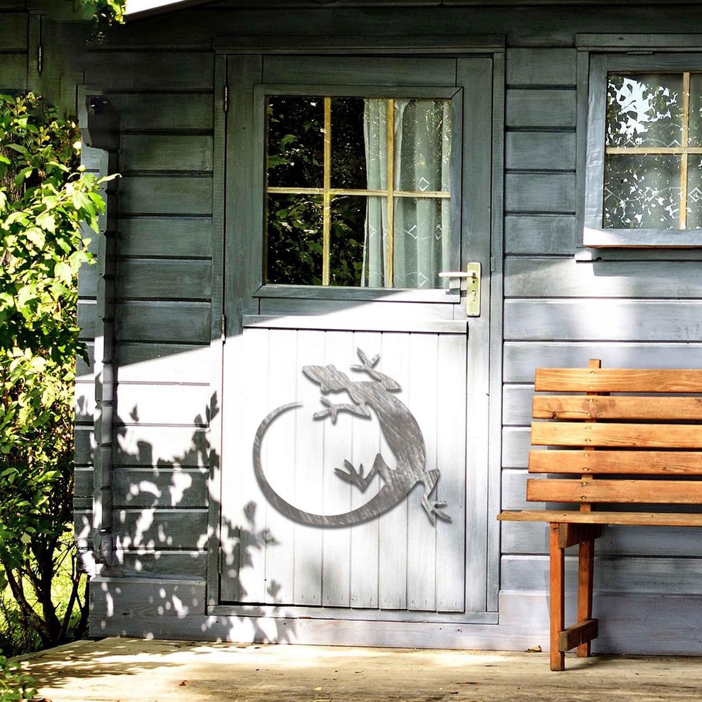 Metal garden decoration featuring a gecko silhouette design with a curved tail, adding a sleek and contemporary accent to outdoor walls, seamlessly complementing rustic and minimalist spaces.