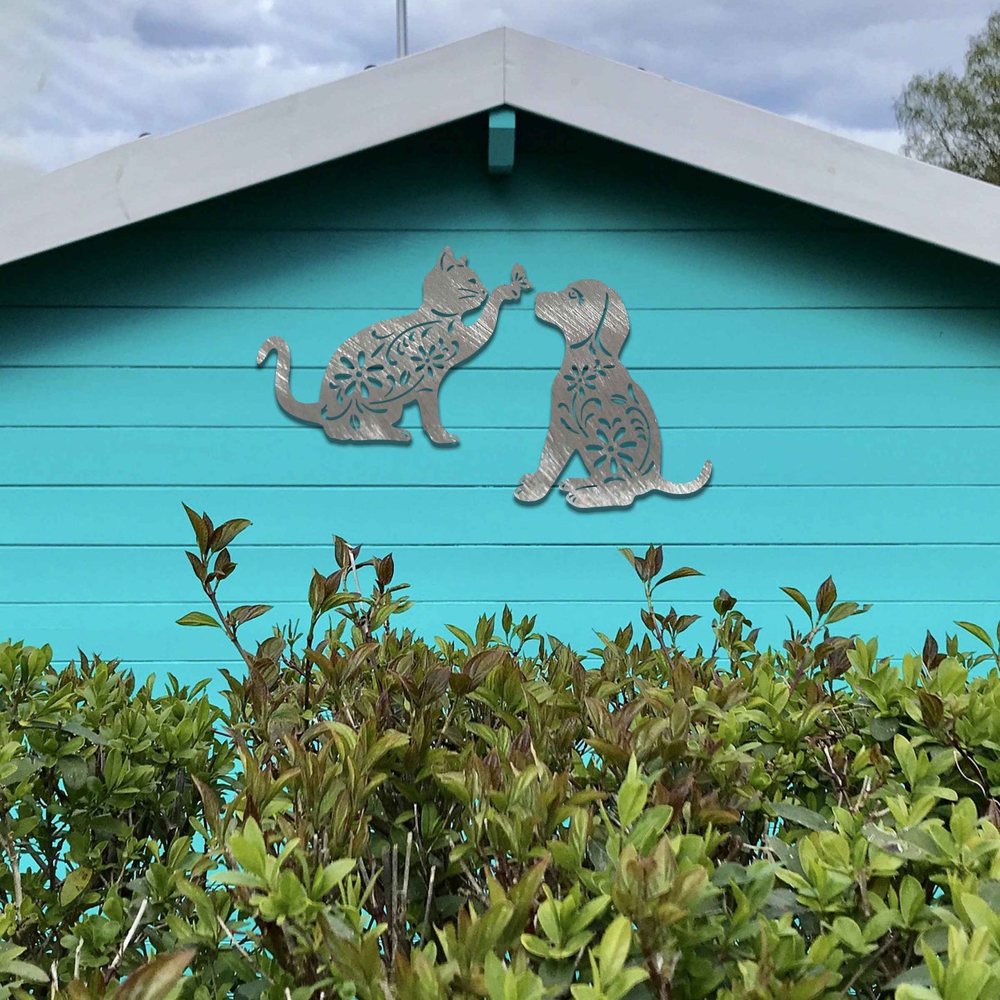 Metal garden decoration set featuring a playful cat reaching for a butterfly and a sitting dog, both adorned with intricate floral patterns, adding a whimsical and charming touch to outdoor walls or fences.