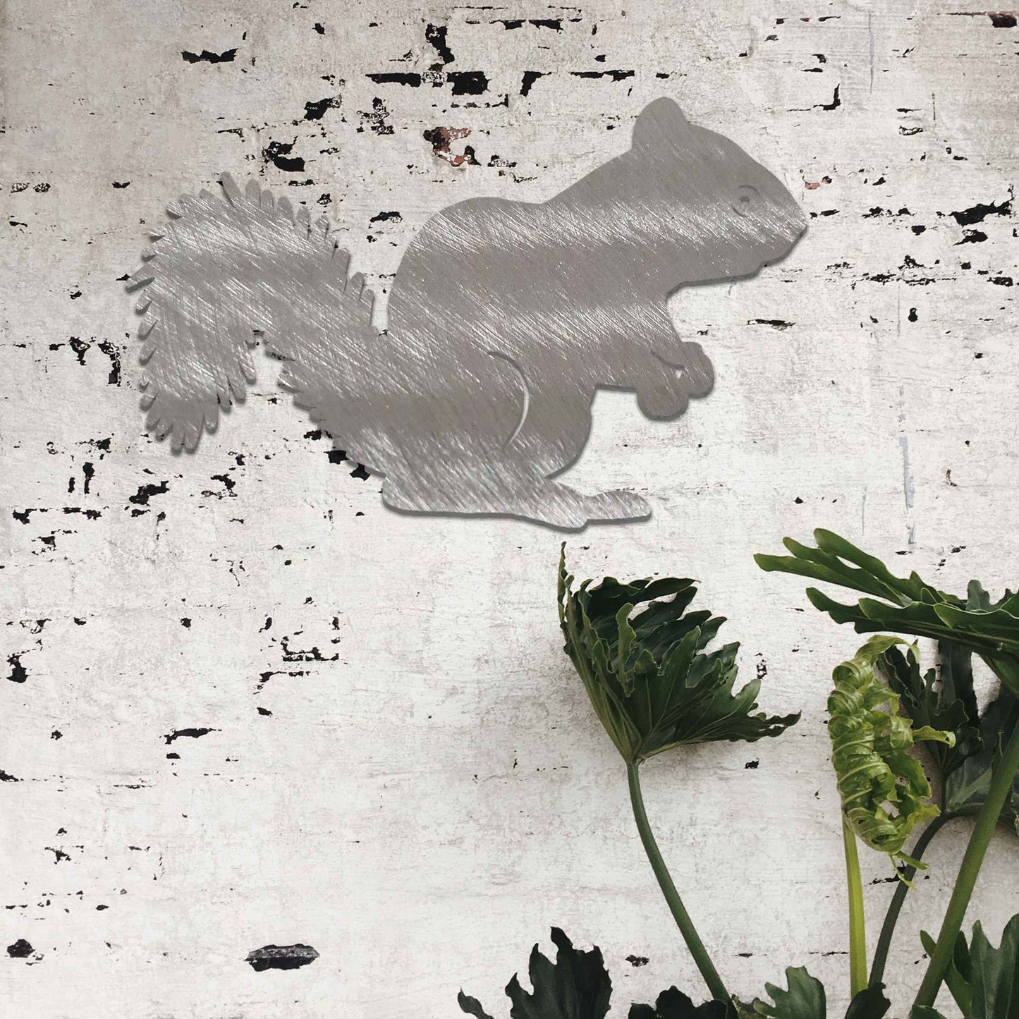 Metal garden decoration featuring a squirrel silhouette with a textured design, adding a rustic and playful accent to outdoor walls, complementing natural and minimalist garden aesthetics.