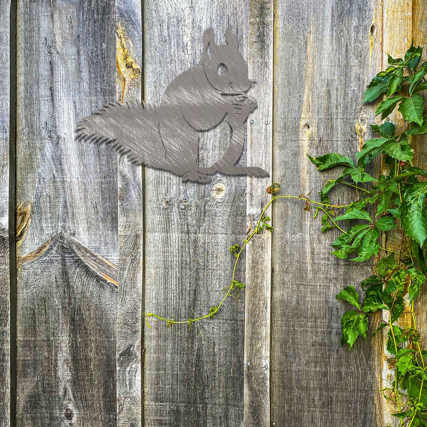 Metal wall decoration featuring a squirrel design with intricate details, adding a playful and artistic touch to indoor spaces, displayed on a neutral wall to highlight its elegant craftsmanship.