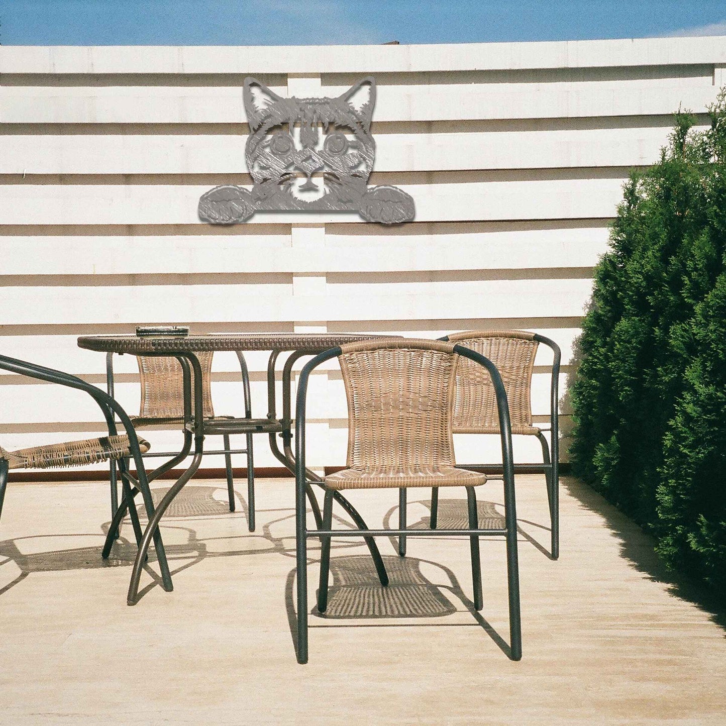 A charming metal wall art piece featuring an adorable cat peeking over a surface, its wide eyes and paws reaching out, adding a playful and endearing touch to modern home decor.