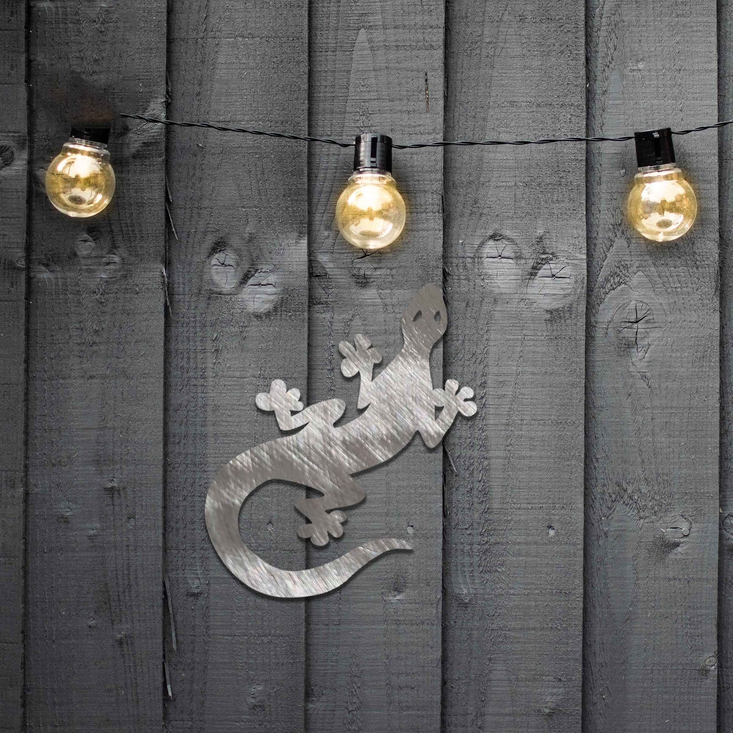 Metal garden decoration featuring a playful gecko silhouette with distinct rounded feet and curved tail, adding a modern and lively touch to outdoor walls, perfectly suited for rustic and contemporary garden settings.