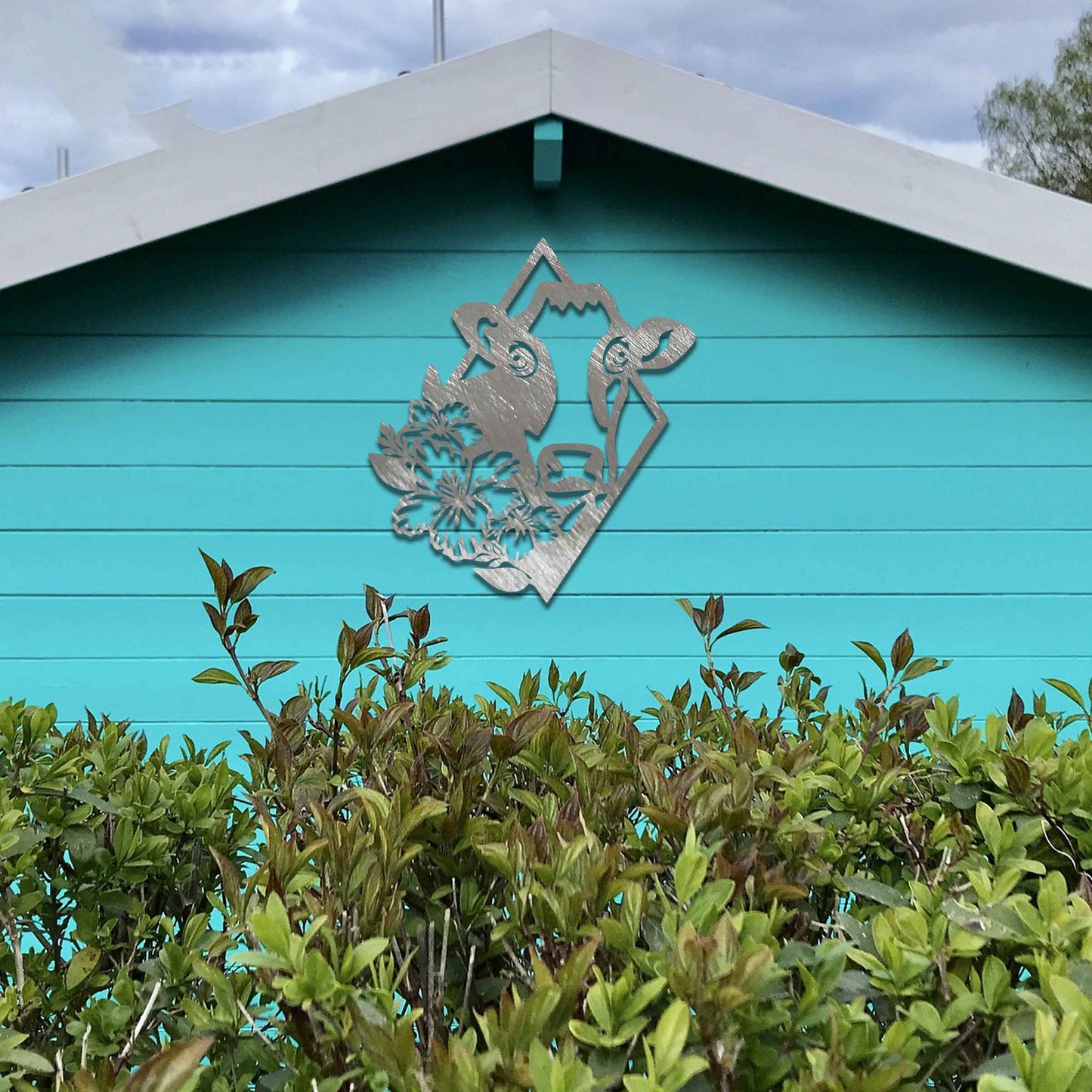 The design features a cow's face framed by a geometric shape, with flowers on its side, combining natural and abstract elements in a modern, stylized way.