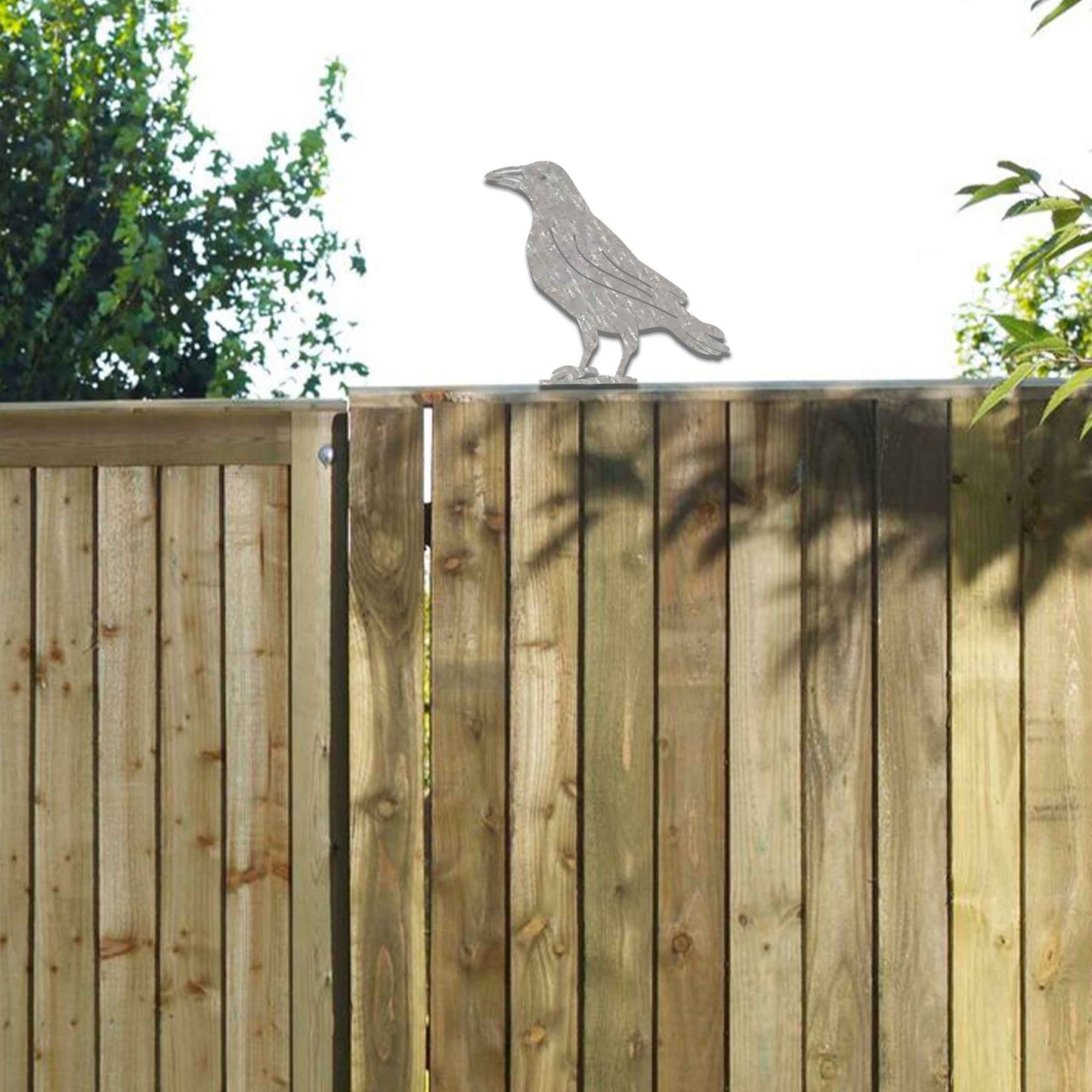 Metal garden decoration featuring a crow silhouette with a rustic finish, designed to sit atop fences or garden posts, adding a bold and distinctive touch to outdoor spaces.