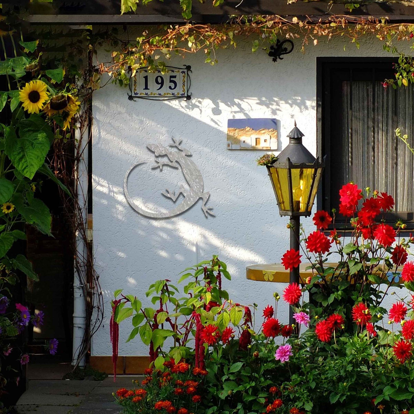 Metal garden decoration featuring a gecko silhouette design with a curved tail, adding a sleek and contemporary accent to outdoor walls, seamlessly complementing rustic and minimalist spaces.