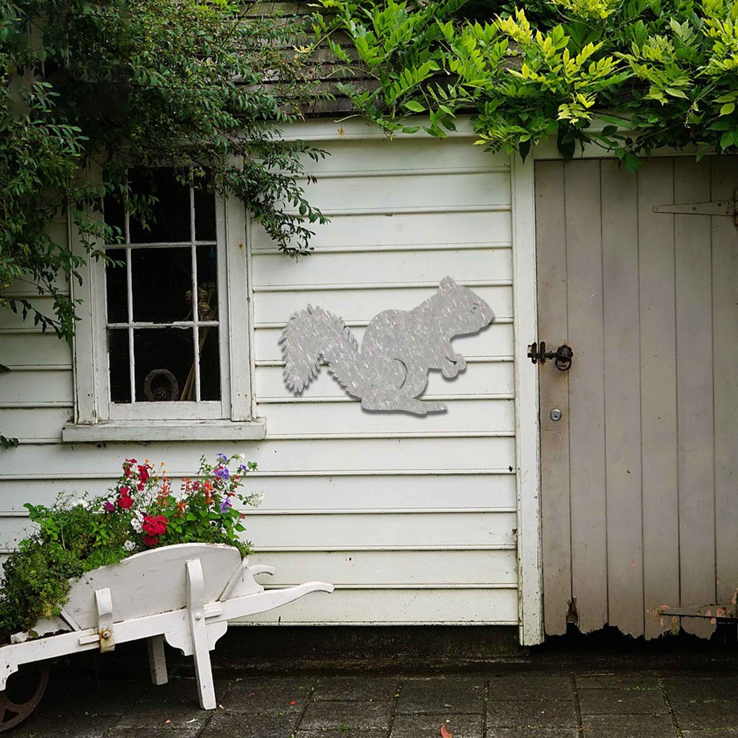 Metal garden decoration featuring a squirrel silhouette with a textured design, adding a rustic and playful accent to outdoor walls, complementing natural and minimalist garden aesthetics.