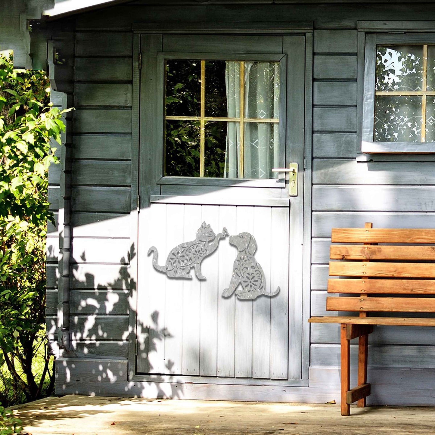 Metal garden decoration set featuring a playful cat reaching for a butterfly and a sitting dog, both adorned with intricate floral patterns, adding a whimsical and charming touch to outdoor walls or fences.