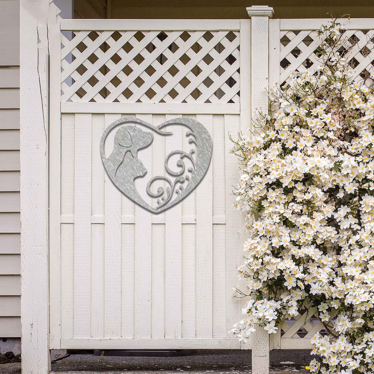 Metal garden decoration featuring a heart-shaped design with silhouettes of a dog and cat intertwined with elegant scrollwork, symbolising love for pets and adding a decorative charm to outdoor walls or garden spaces.