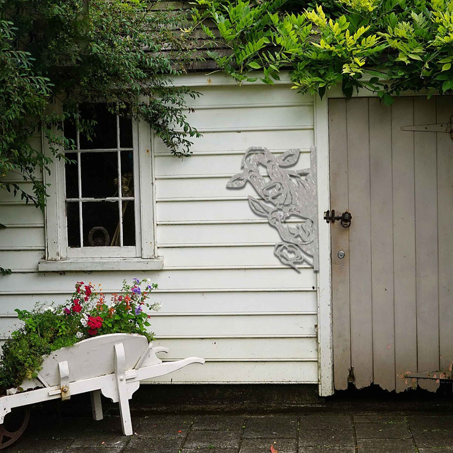 Metal decoration featuring a cow, a donkey, and a goose peeking around a vertical edge, crafted with intricate cutout details and a rustic finish, adding a whimsical and rustic charm to outdoor or garden spaces.