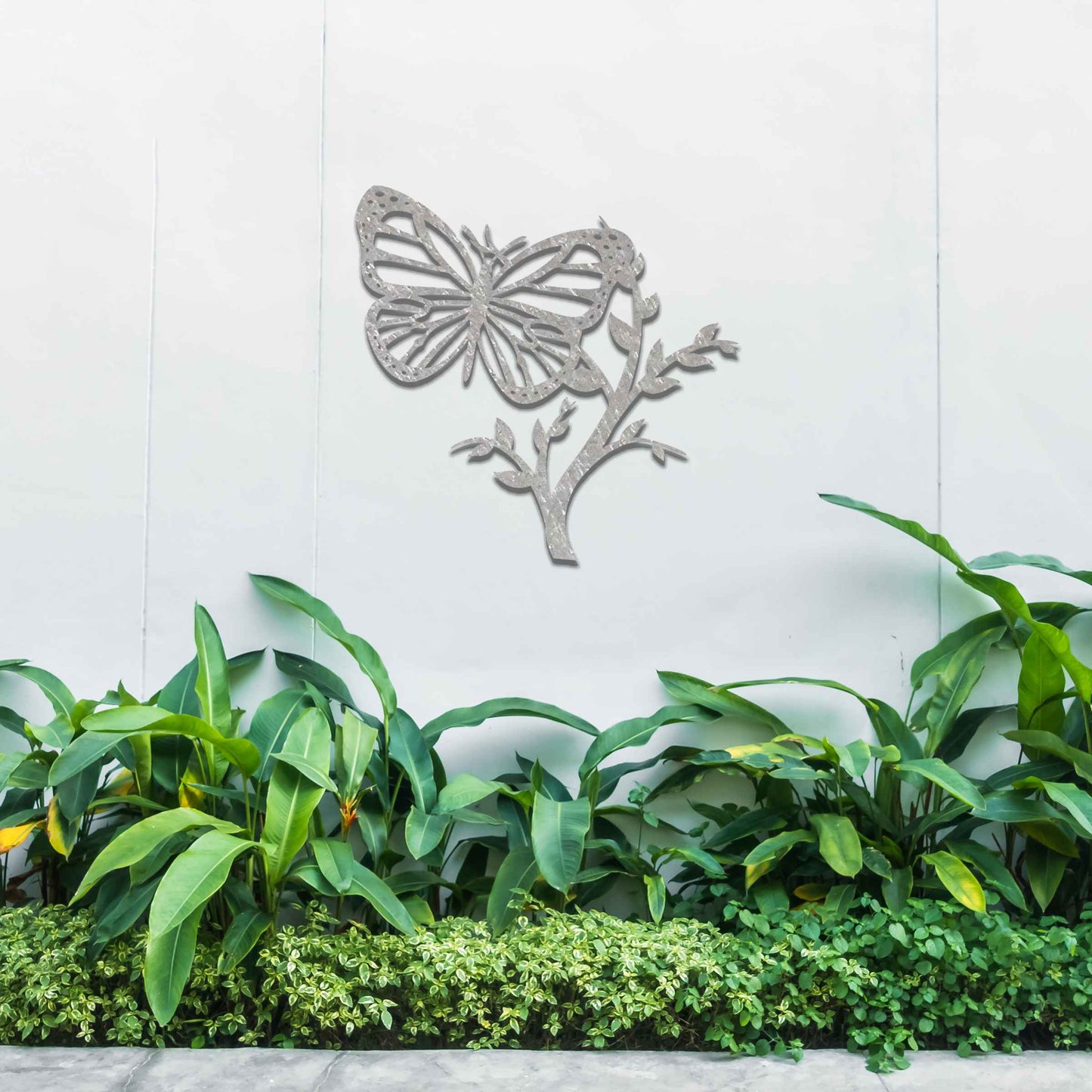 Metal garden decoration featuring a butterfly resting on a leafy branch, crafted with intricate detailing to bring a touch of nature-inspired elegance and charm to outdoor walls or garden settings.