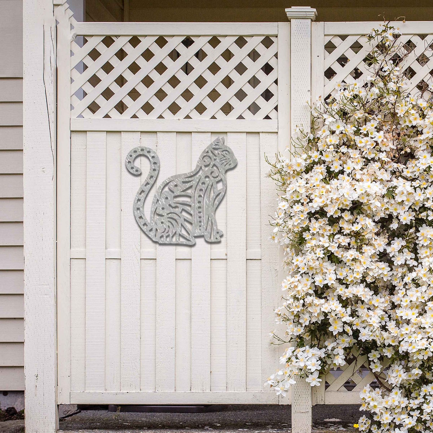 Metal garden decoration featuring a sitting cat with an intricate geometric and swirl pattern, adding a playful and artistic touch to outdoor walls or garden settings.