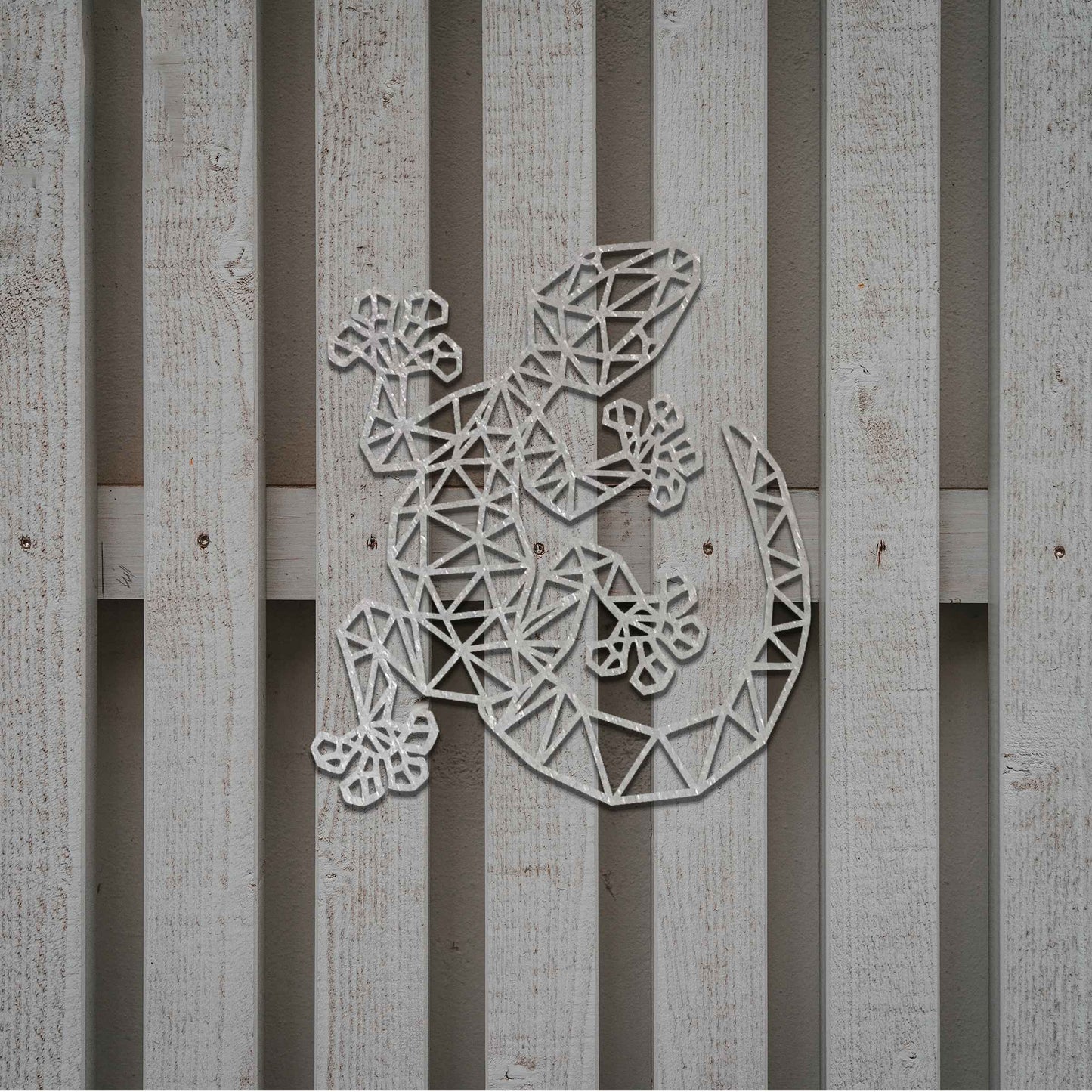 Metal garden decoration featuring a gecko-shaped design with geometric cutouts, bringing a modern and artistic flair to outdoor spaces, seamlessly complementing the surrounding greenery.