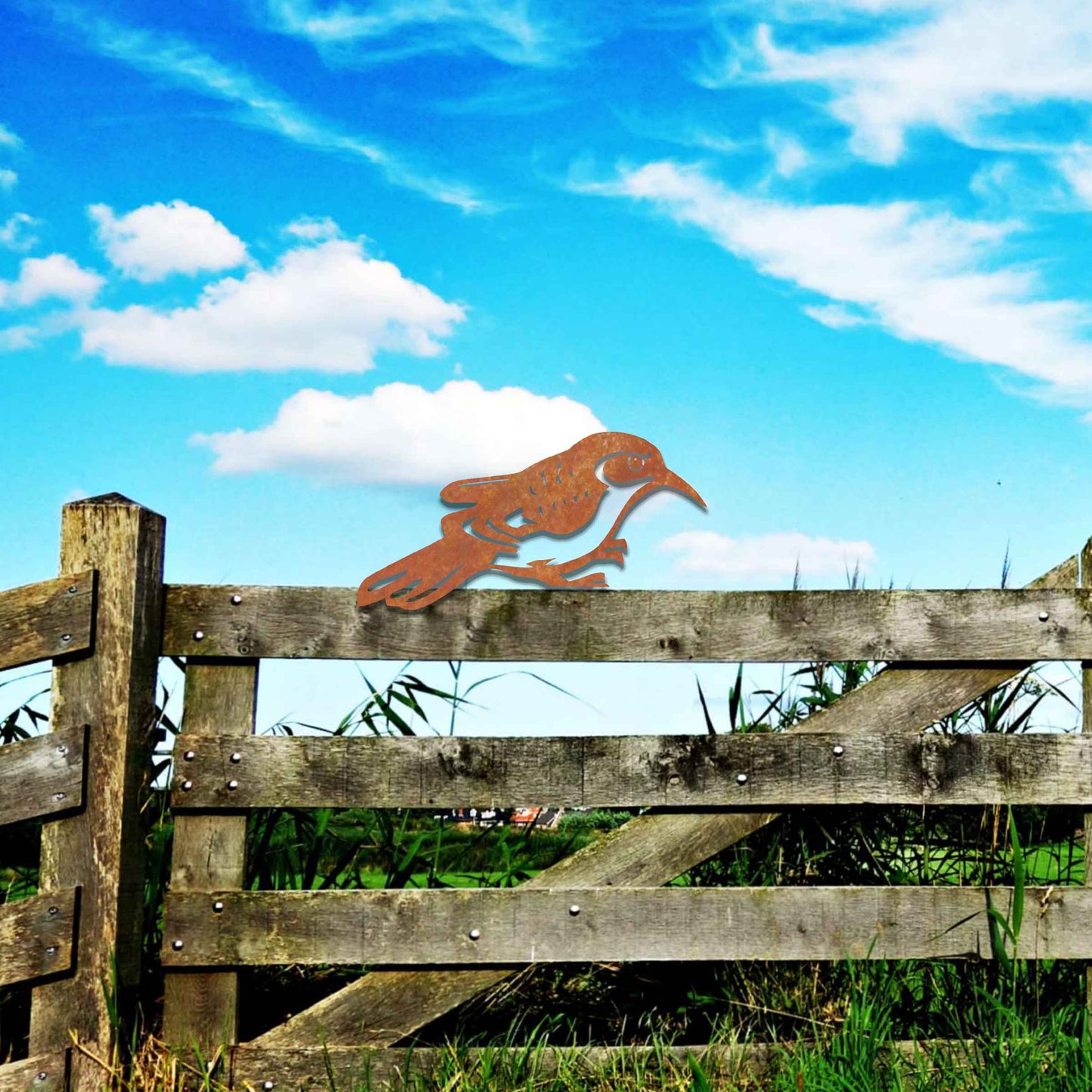 Metal garden decoration featuring a bird silhouette with intricate cutout details, adding a sleek and modern touch to outdoor spaces, designed to sit gracefully on fence posts or wooden beams.