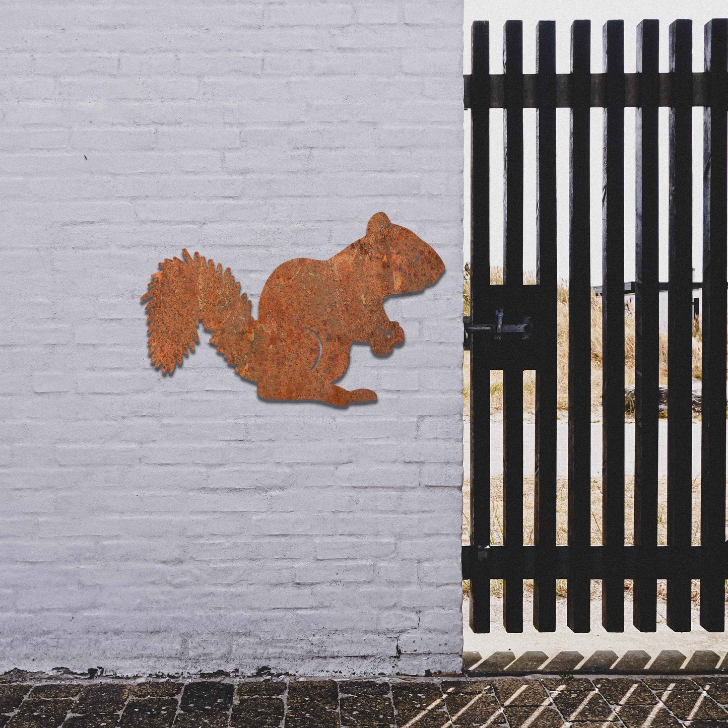 Metal garden decoration featuring a squirrel silhouette with a textured design, adding a rustic and playful accent to outdoor walls, complementing natural and minimalist garden aesthetics.