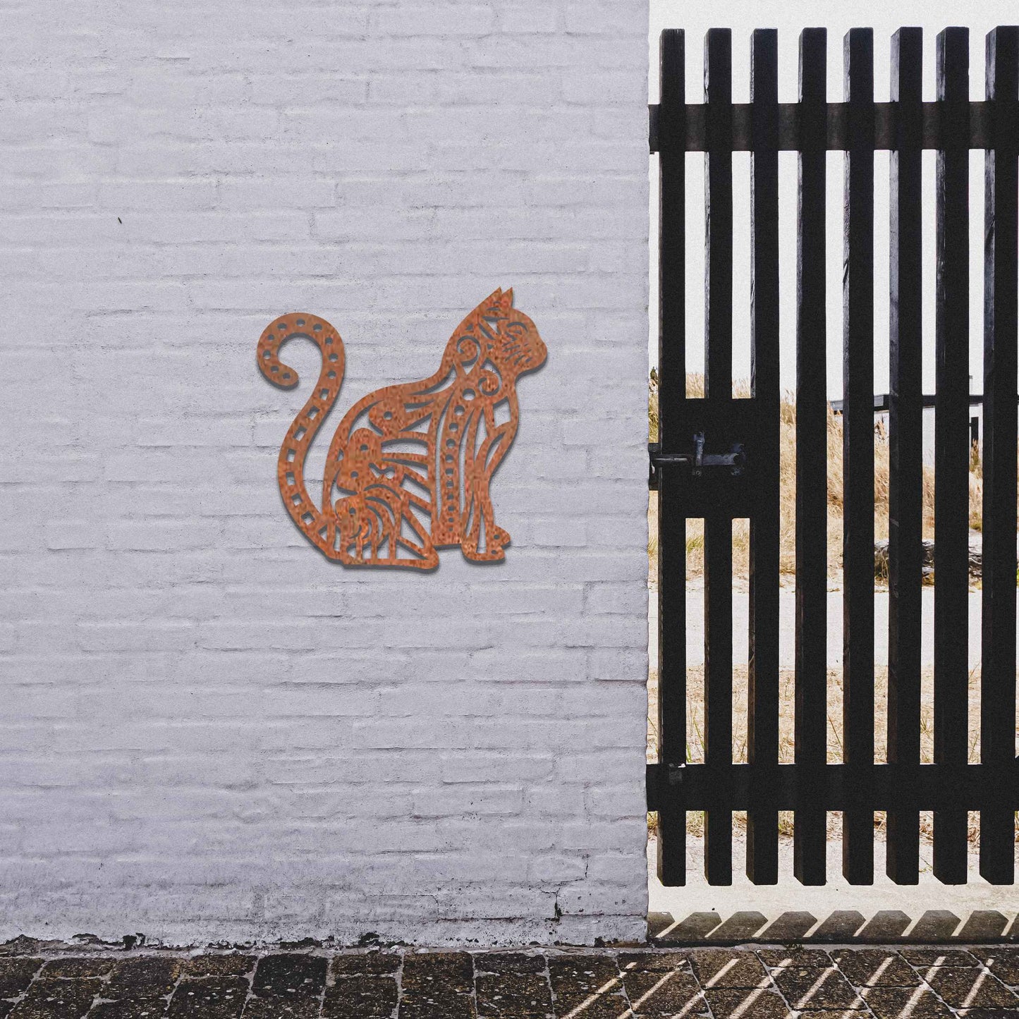 Metal garden decoration featuring a sitting cat with an intricate geometric and swirl pattern, adding a playful and artistic touch to outdoor walls or garden settings.