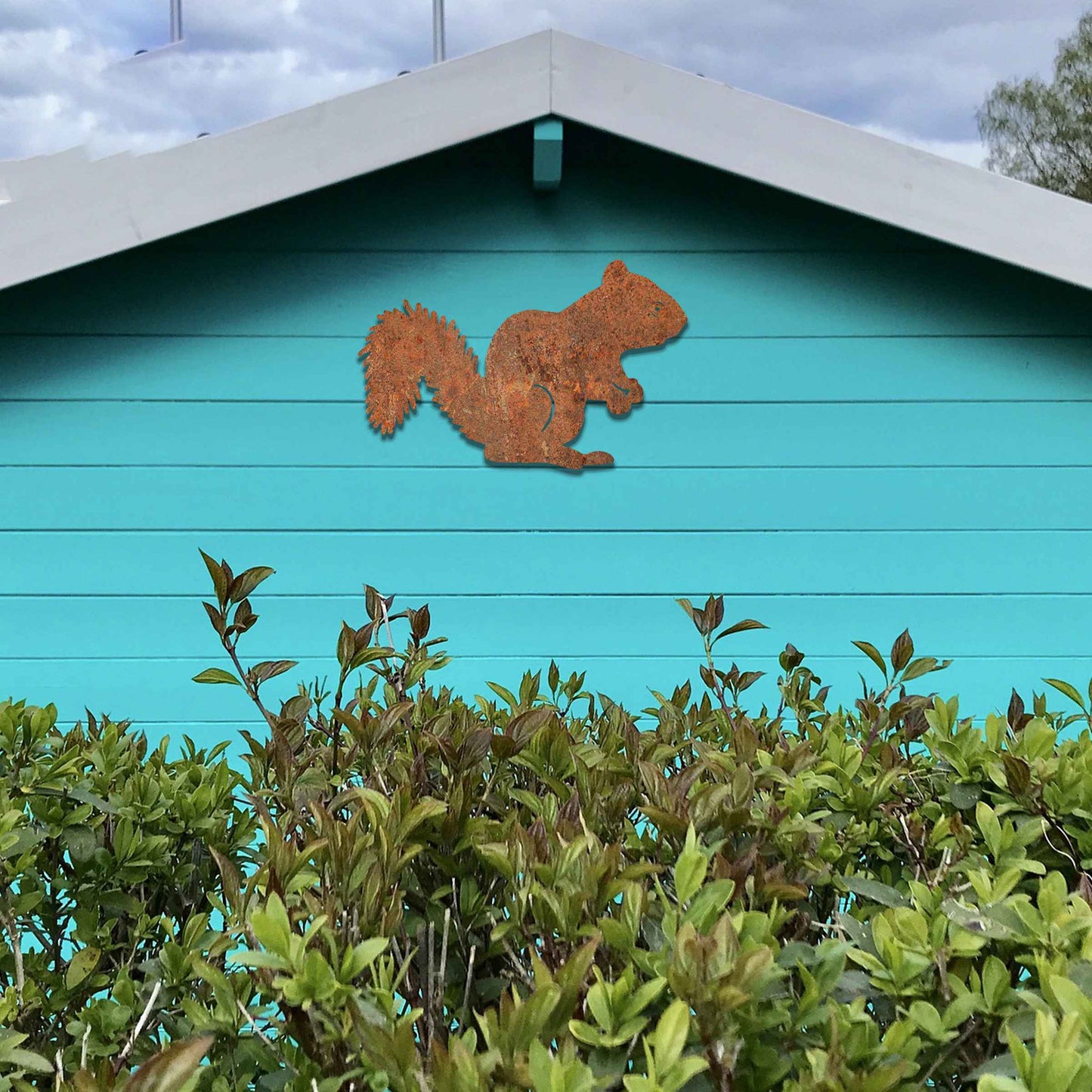 Metal garden decoration featuring a squirrel silhouette with a textured design, adding a rustic and playful accent to outdoor walls, complementing natural and minimalist garden aesthetics.