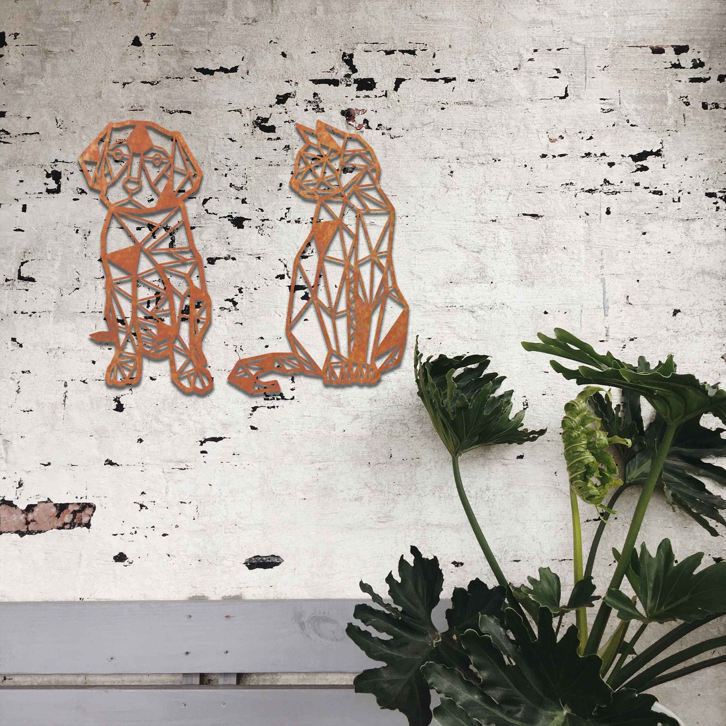 This image displays geometric-style black metal art featuring a dog and a cat, placed side by side. The angular, modern design of the animals contrasts beautifully with the natural greenery around, offering a stylish touch to the surrounding space.