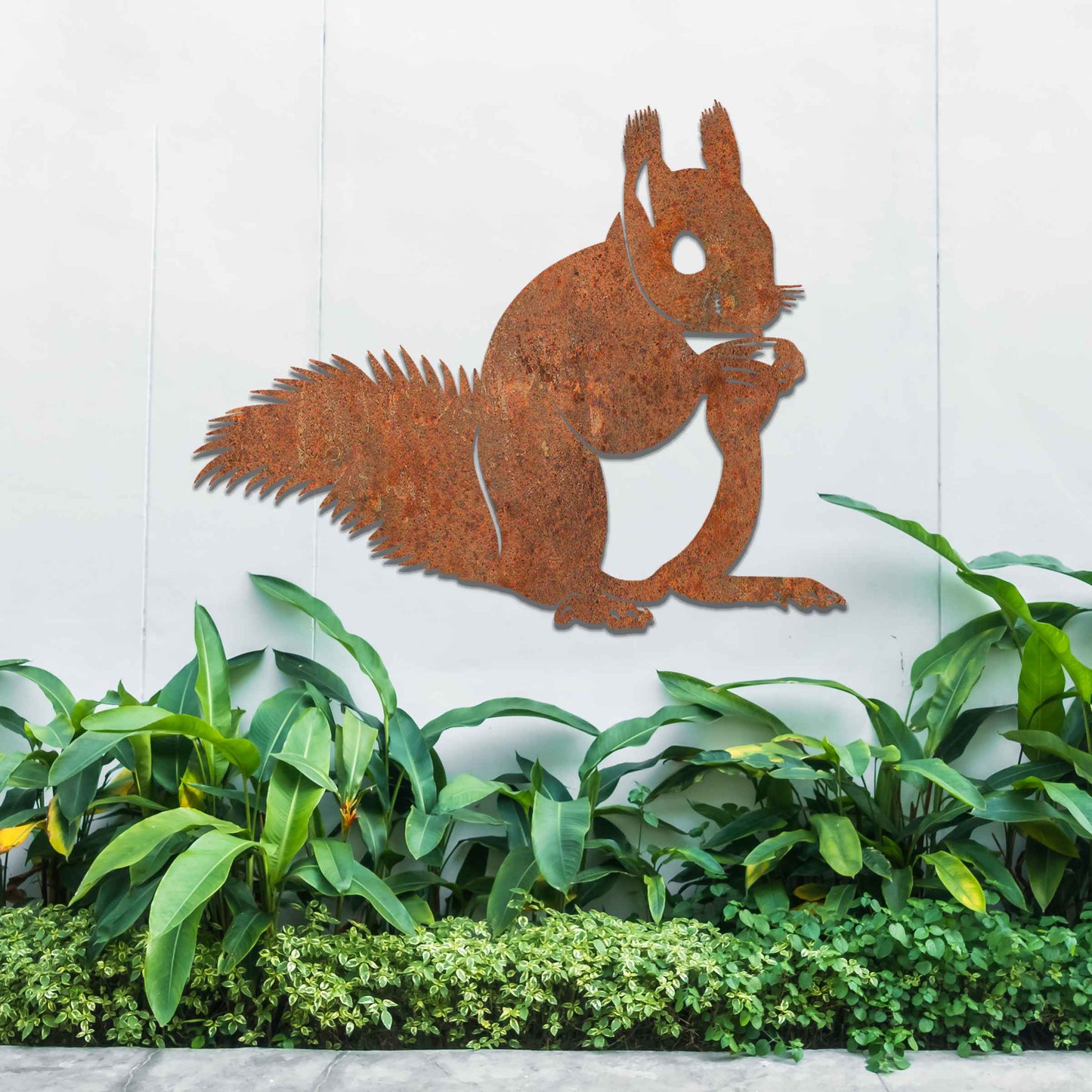 Metal wall decoration featuring a squirrel design with intricate details, adding a playful and artistic touch to indoor spaces, displayed on a neutral wall to highlight its elegant craftsmanship.