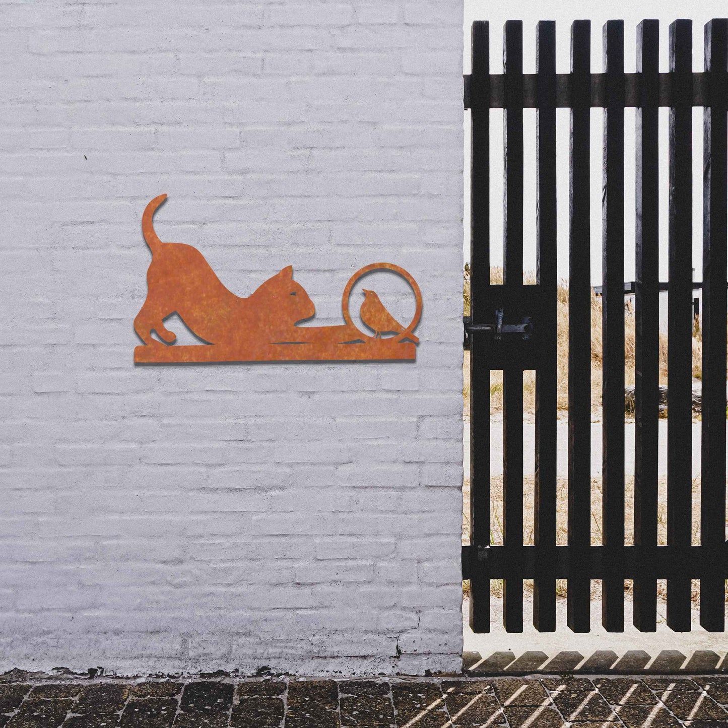 Metal wall art featuring a playful cat crouching in curiosity with a bird perched nearby, perfect for adding a touch of whimsy and nature-inspired charm to your garden, fence, or outdoor decor.