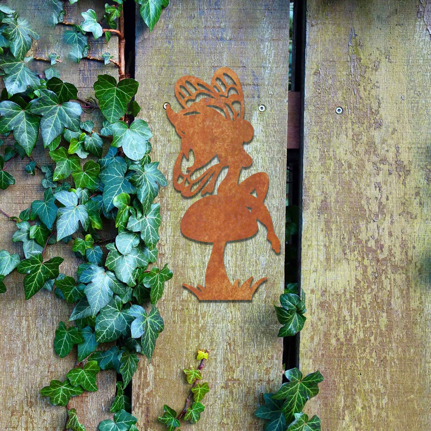 This image features a fairy perched on a mushroom, its silhouette highlighted by intricate wings. The whimsical design is enhanced by the playful stance of the fairy, adding a touch of enchantment to any garden or outdoor space.