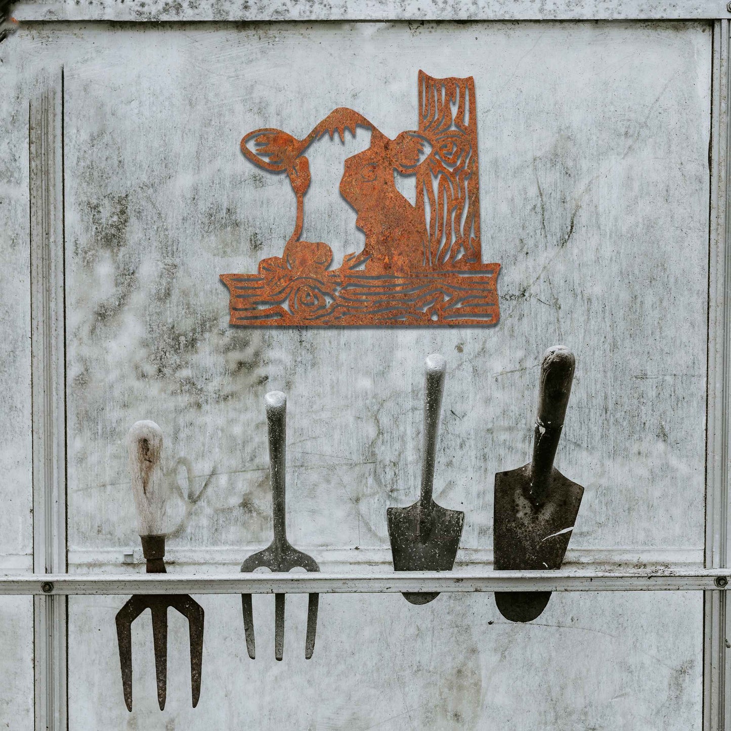 The design features a cow's head peeking over a wooden fence. The cow is drawn with distinct lines, giving it a playful and curious look. The stylized wooden posts complement the cow’s design, adding depth and structure.