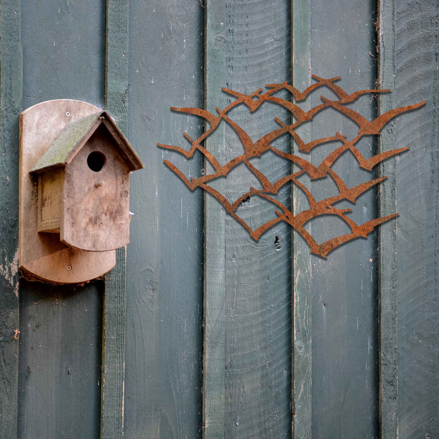 A stunning metal wall art featuring an abstract flock of birds in flight. This dynamic piece brings an element of freedom and movement to your space, complementing lush green surroundings for a serene and modern aesthetic.