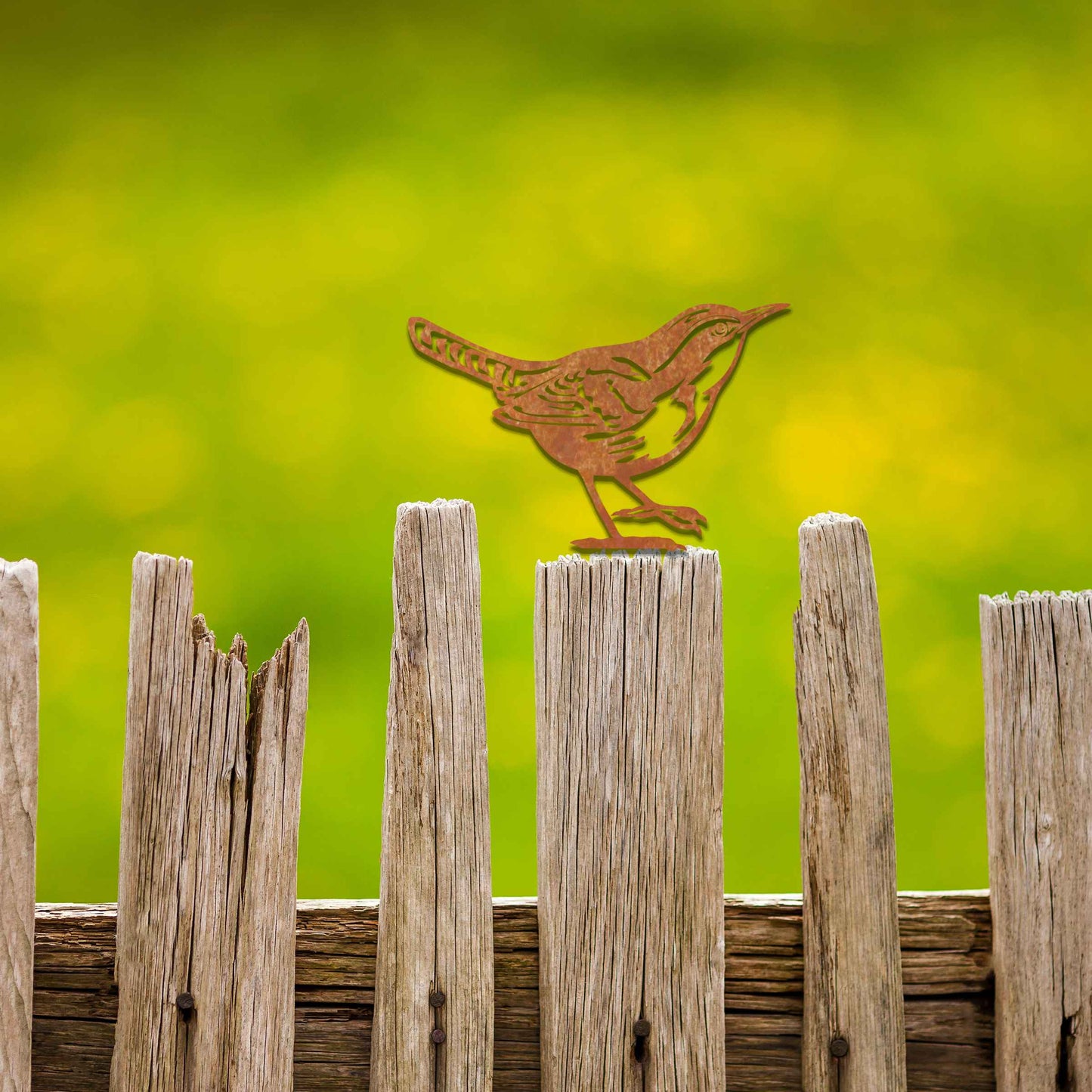 Metal garden decoration featuring a wren silhouette with intricate cutout details and a rustic finish, designed to sit atop fences or posts, adding a delicate and natural charm to outdoor spaces.