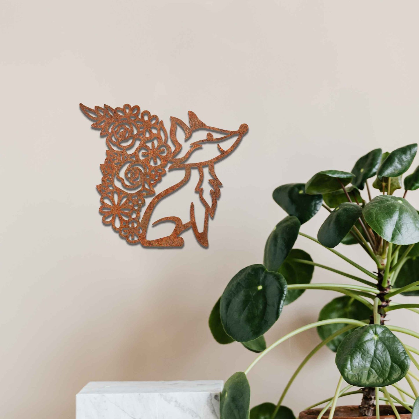 Metal wall decoration featuring a fox silhouette with a floral-patterned tail, crafted with intricate cutout details and a rustic finish, adding a whimsical and elegant touch to indoor or outdoor spaces.