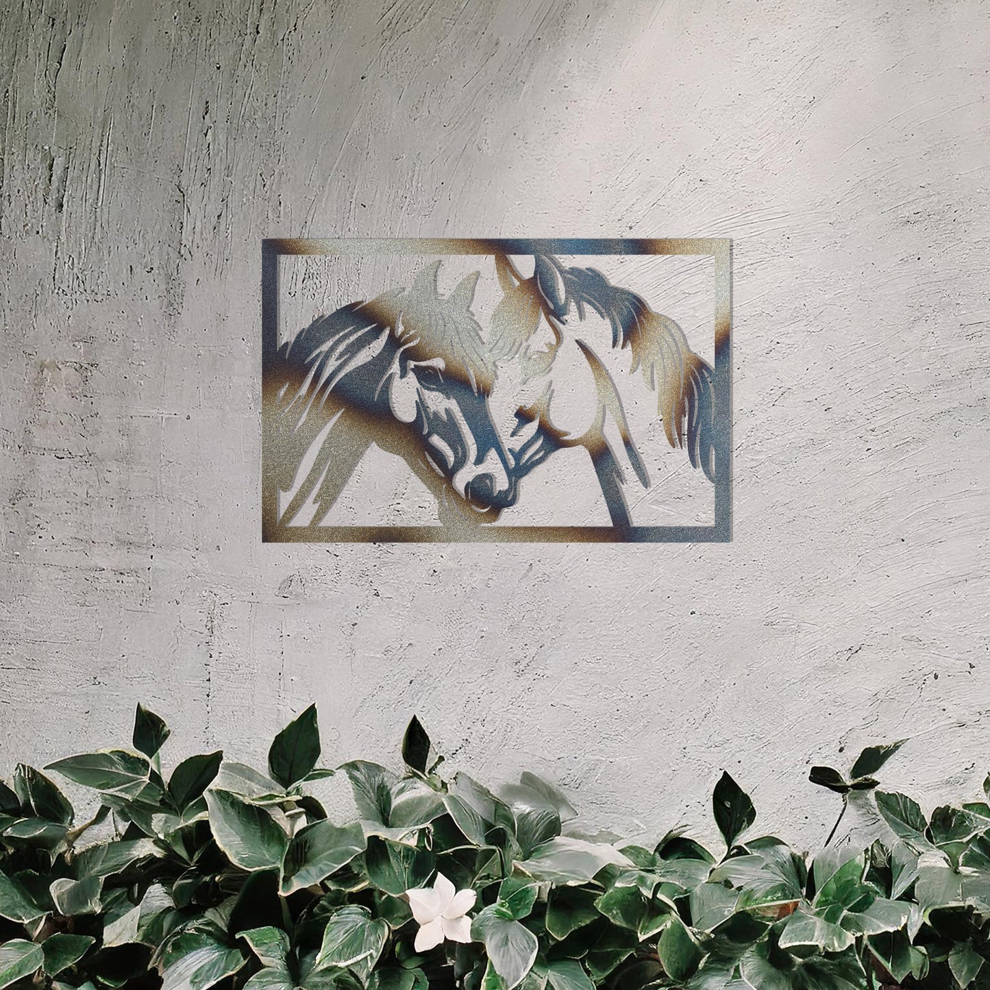 A captivating metal wall art design showcasing two horses facing each other within a rectangular frame, symbolising connection and affection. This piece beautifully complements a neutral wall in a serene and elegantly decorated outdoor space.