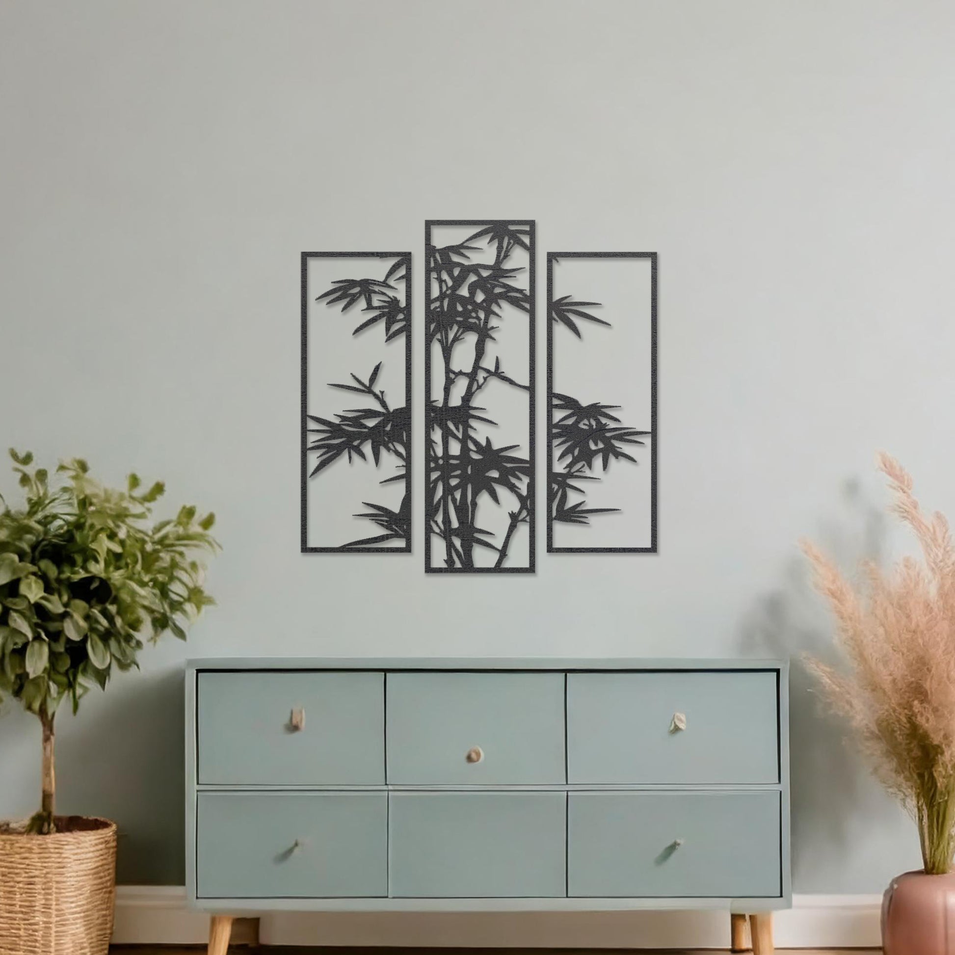Wooden wall art consisting of three panels featuring a bamboo design with detailed leaves and stalks, displayed on a neutral wall within modern room decor, highlighting its elegant and nature-inspired craftsmanship.