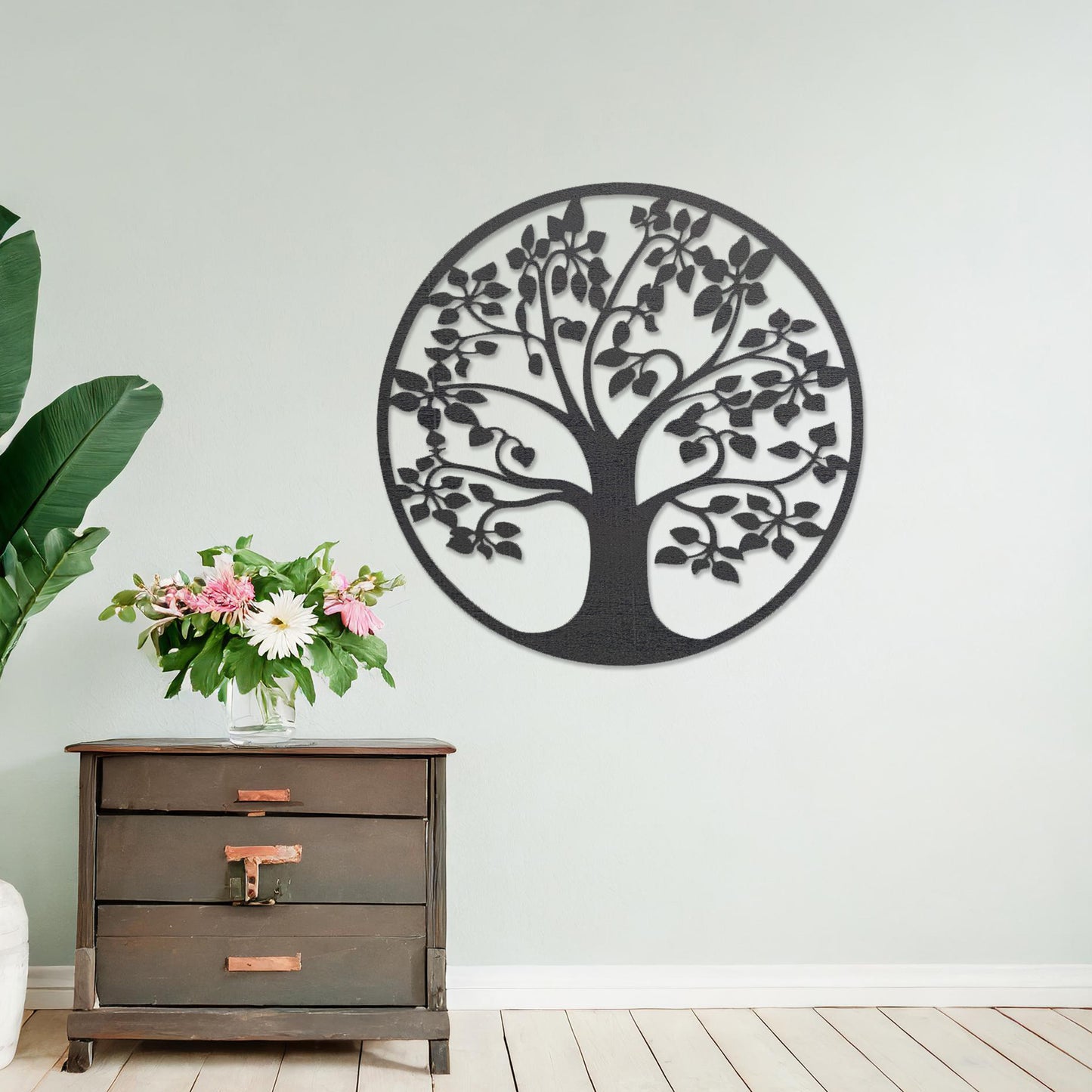 Wooden wall art featuring a circular tree design with detailed leaves and branches, displayed on a neutral wall within modern room decor, emphasising its natural elegance and intricate craftsmanship.