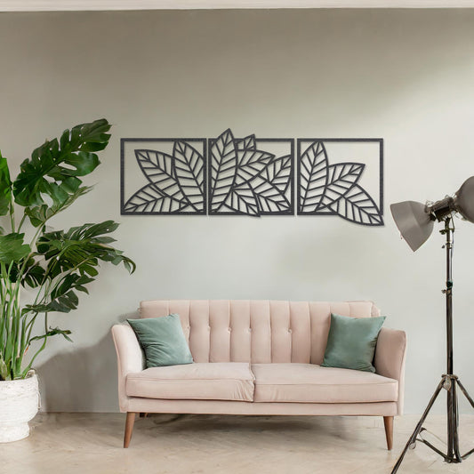 Wooden wall art featuring a three-panel design of overlapping leaf patterns with intricate cut-outs. The artwork is displayed on a neutral wall within modern room decor, highlighting its natural and elegant design.