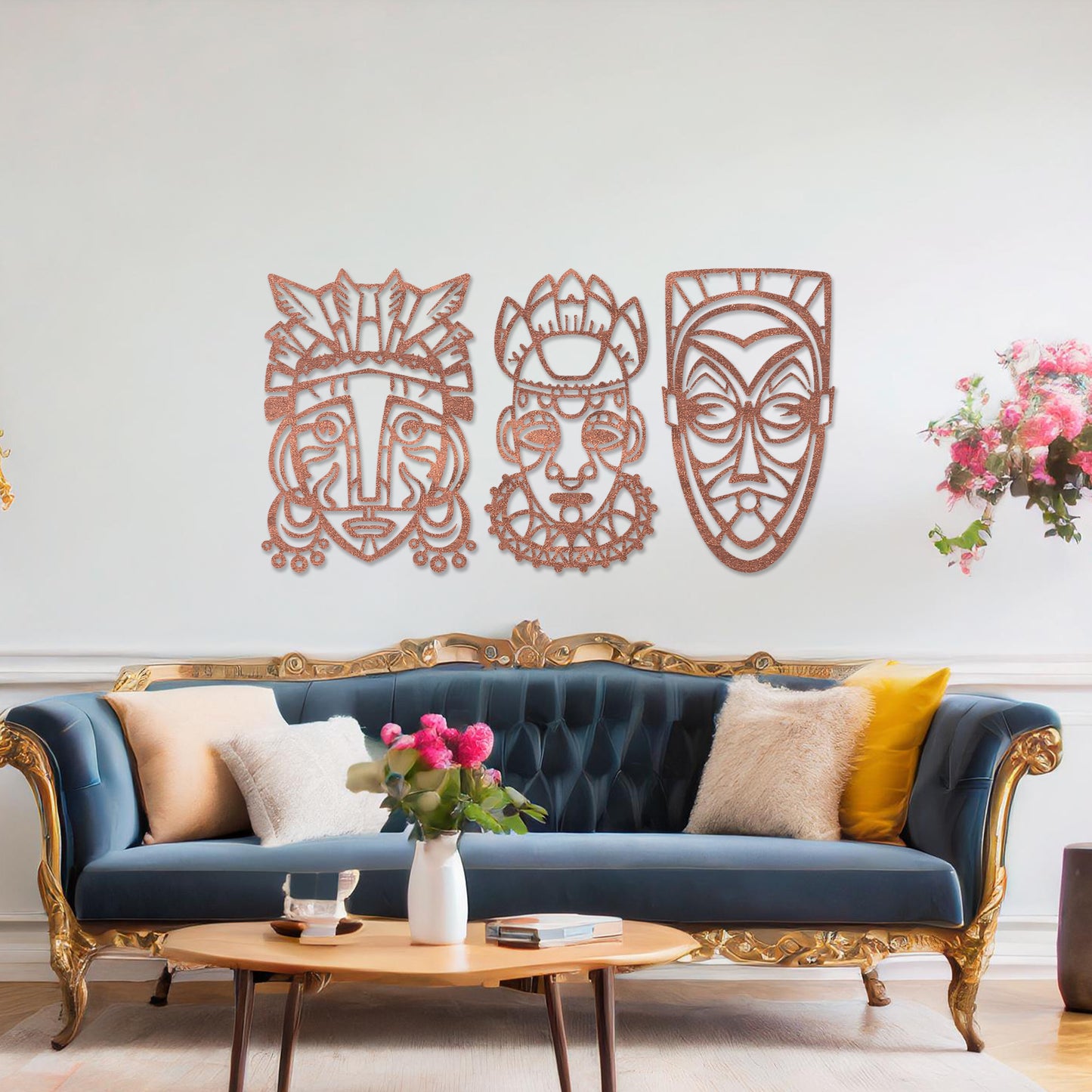 This is a wall art design featuring three tribal masks with intricate details, displayed on a neutral wall. The masks' features and patterns create an eye-catching, cultural focal point, enhancing the modern room's decor.