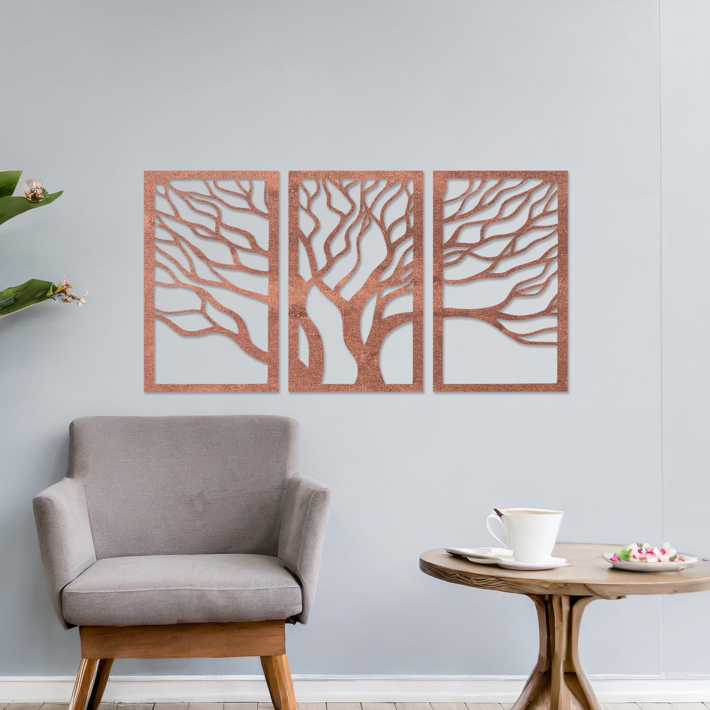 A three-panel wall art featuring a minimalist tree design with flowing, intricate branches. The artwork is displayed on a neutral wall in a modern living room, complementing the contemporary decor and adding a touch of natural elegance.